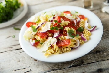 Pasta salad with mozzarella, red onion and tomato