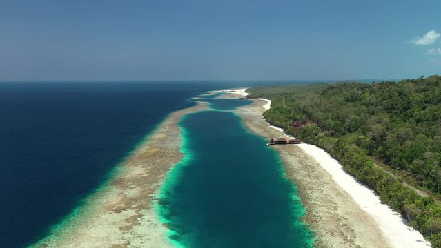 Drone view of lagoon formation when is low tide on a tropical island  with a dock seen by far