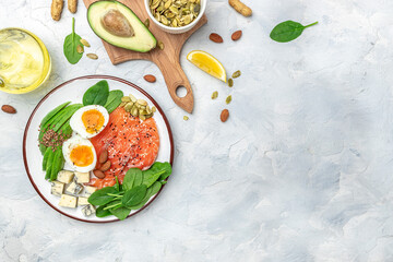 Ketogenic diet breakfast. salmon, avocado, cheese, egg, spinach and nuts. Healthy fats, clean eating for weight loss. banner, menu, recipe place for text, top view