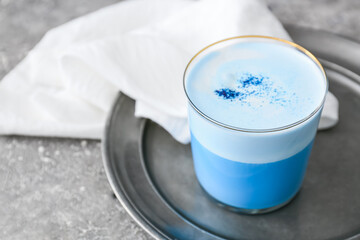 Glass of blue matcha tea on grey grunge background