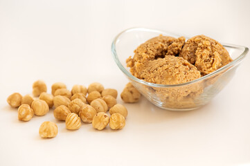 Hazelnut butter, spread, hummus with whole nuts on white background. Natural local cuisine in the Mediterranean region. Selective focus on spread in the glass bowl.