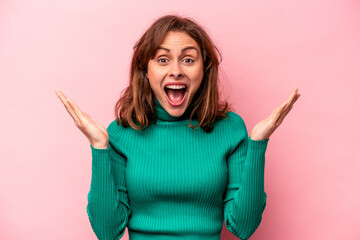 Young caucasian woman isolated on pink background receiving a pleasant surprise, excited and...