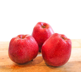 Red delicious apples on wooden table isolated on white background.