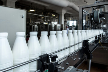 White plastic milk bottles on the conveyor on a modern dairy plant