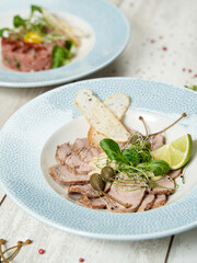 Grilled turkey meat with cheese sauce and capers
