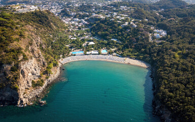 Sandy beach in a bay surrounded by hills (aerial drone photo). Ischia island, Italy - obrazy, fototapety, plakaty