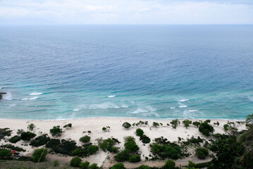 Beautiful view of Cristo Rei Backside Beach or known as Dolok Oan Beach in Dili, Timor Leste. Sea waves background. Aerial view of tropical beach.