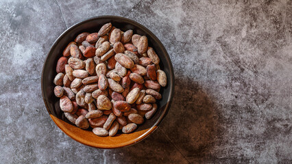 Brown dried cocoa beans in a bowl