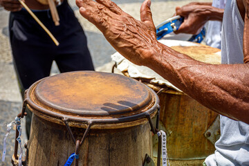 Fototapeta na wymiar Musicians playing traditional instruments used in capoeira, a mix of fight and dance from Afro-Brazilian culture in the streets of Pelourinho in Salvador, Bahia