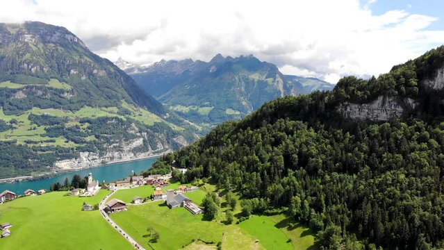 Aerial flyover over the village of Seelisberg with a spinning panoramic view of Lake Lucerne and various mountain peaks around Uri, Switzerland such as Niederbauen- Chulm, Fronalpstock, Pilatus