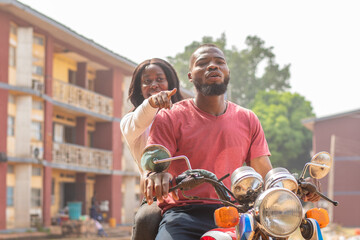 african lady on a bike showing the rider direction to take