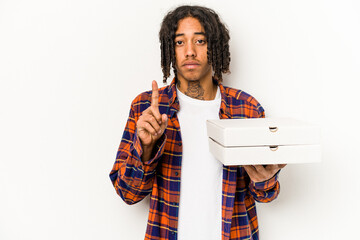 Young African American man holding pizzas isolated on blue background showing number one with finger.