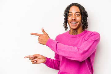 Young African American man isolated on white background pointing with forefingers to a copy space, expressing excitement and desire.