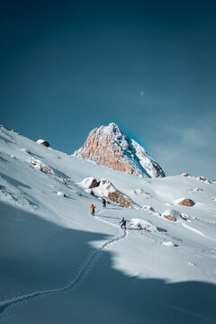 Vertical photo of people skiing in snowy mountains