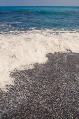Sea water from a wave with foam on the seashore