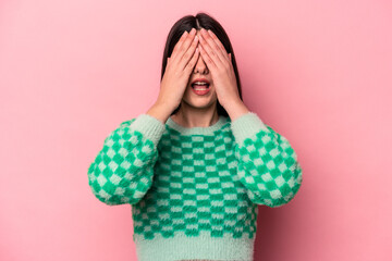 Young caucasian woman isolated on pink background having fun covering half of face with palm.