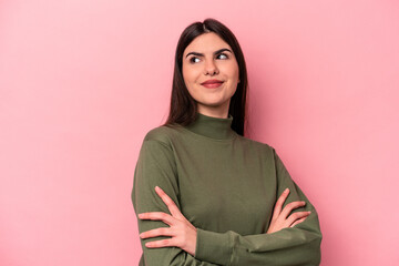 Young caucasian woman isolated on pink background dreaming of achieving goals and purposes