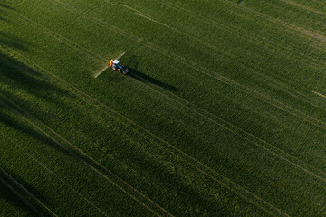 Aerial view of tractor spraying pesticides at agriculture field