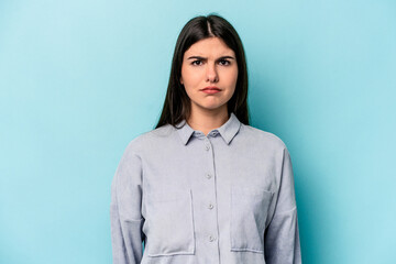 Young caucasian woman isolated on blue background sad, serious face, feeling miserable and...