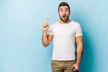 Young man with crutches isolated on blue background having some great idea, concept of creativity.