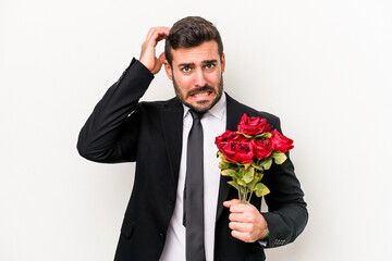 Young caucasian man holding a bouquet of flowers isolated on white background being shocked, she...