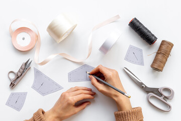 Female hands holding sewing patterns. Sewing background for dress workshop