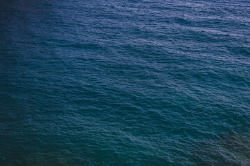 ocean or sea water textured dark blue background. surface and texture of calm shallow waves and depth. summer nature landscape