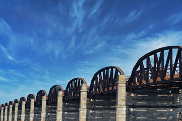 old rusty steel railway bridge with arches