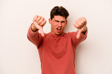 Young caucasian man isolated on white background showing thumb down and expressing dislike.