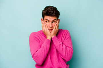 Fototapeta premium Young caucasian man isolated on blue background scared and afraid.