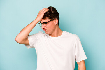 Young caucasian man isolated on blue background forgetting something, slapping forehead with palm and closing eyes.