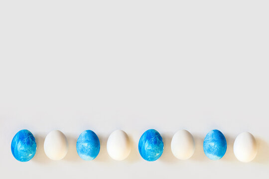 Easter frame with blue and white color eggs isolated on gray background. Stylish trendy minimal set or composition with natural painted egg. Flat lay, top view, place for text. Happy egg hunt concept