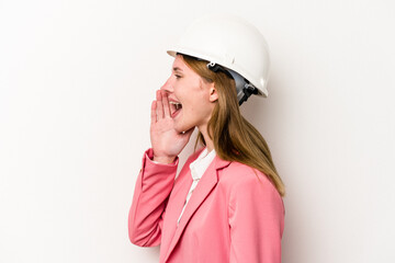 Young architect English woman with helmet isolated on white background shouting and holding palm near opened mouth.