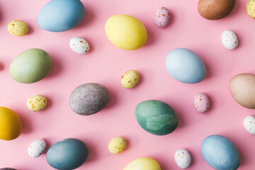 Stylish eggs flat lay on pink background. Modern natural dyed colorful easter eggs and and...