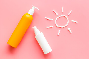 Sunscreen in bottles flatlay with sun made of white cream