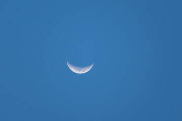View of a beautiful waning crescent moon in a blue sky © Maik Kleinert/Wirestock Creators