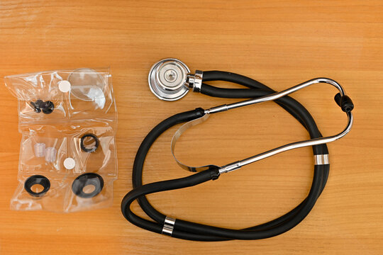 Medical Stethoscope With Spare Parts. New Stethoscope. Wooden Background. Top View.