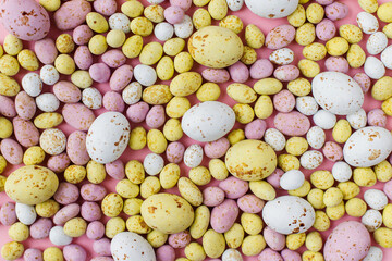 Fototapeta na wymiar Colorful chocolate eggs easter background. Stylish colorful candy easter eggs flat lay on pink background. Candy banner. Happy Easter