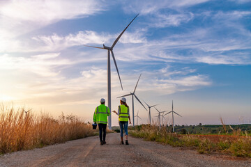 Engineer wearing uniform ,helmet hold document inspection work in wind turbine farms rotation to...