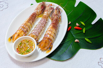 steamed crayfish or mantis shrimps on white disk with seafood sauce Thai Food