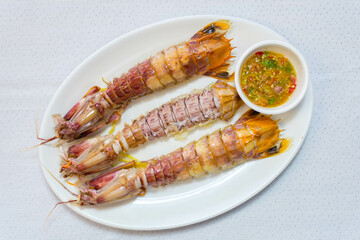 steamed crayfish or mantis shrimps on white disk with seafood sauce Thai Food