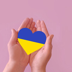 love blue and yellow heart in hands on colorful background.  Ukraine concept 