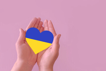 love blue and yellow heart in hands on colorful background.  Ukraine concept 