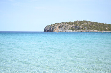 View of an island surrounded by sea on a sunny day