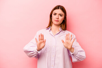 Young caucasian woman isolated on pink background rejecting someone showing a gesture of disgust.