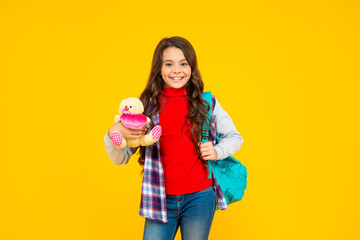 happy child casual style with backpack and toy on yellow background, education