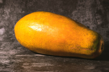Ripe orange papaya isolated on a dark marbled background.