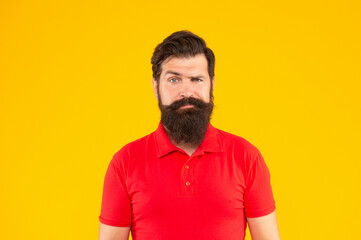 serious bearded man with mustache in tshirt on yellow background, skin care