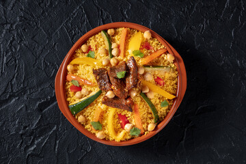 Meat and vegetable couscous, traditional Moroccan food, shot from the top, with chickpeas on a...