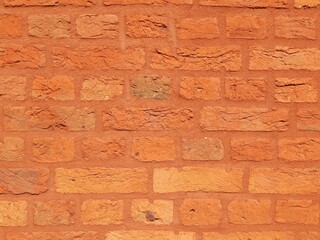 Détail d'un mur de vieilles briques peint en orange pour lui rendre un aspect moderne